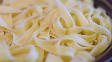 Kuru pappardelle makarna, daire şeklinde dönüş. El yapımı makarna, Turning. Seçici odaklanma. haşlanmış aşçı.