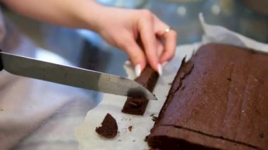 Eller çikolatalı pudingi dilimli fındık kırıntılarıyla kesiyor. - Evet. Yüksek kalite 4k görüntü