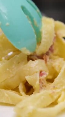 Kamera, masada servis edilen Carbonara makarnasını takip ediyor. Yüksek hızlı kamera ve hayalet kaslı 4K ile çekilmiş. Ağır çekim. Yüksek kalite 4k görüntü