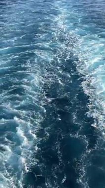 Beyaz dalga köpüğü ve gemi kabarcıkları denizde ya da okyanusta hareket eder. Gün batımında tekne üstüne tekne. Yüksek kalite 4k görüntü