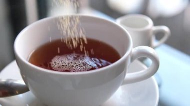 Siyah kahveye şeker koyan koyu kamış şekeri. Şeker kahve fincanına düşer. Kafein Bağımlısı Hurda Yiyecekler. Sağlıksız yeme, diyabet, obezite, kalp hastalığı kavramı. 4k