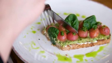 Lezzetli avokado tostu, haşlanmış yumurta ve ıspanaklı vişneli domates. Yüksek kalite 4k görüntü