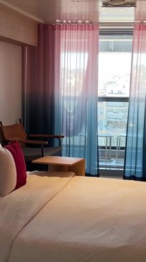 Kabin aynası yastıklar temiz battaniye odası balkon aynalı telefon masası iki kamara balkon yolcu gemisi Virgin Voyages için rahat bir yer. İspanya Barselona 11.2024 