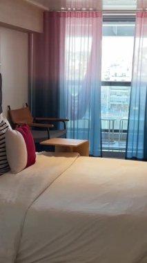 Kabin aynası yastıklar temiz battaniye odası balkon aynalı telefon masası iki kamara balkon yolcu gemisi Virgin Voyages için rahat bir yer. İspanya Barselona 11.2024 