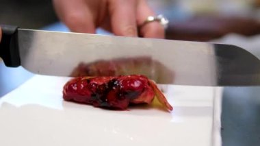 Şekerci kadın bayram için lezzetli bir vişneli pasta hazırlıyor. Pastayı kes. Yüksek kalite 4K görüntü. Yüksek kalite 4k görüntü