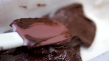 Konservelerin içine çikolatalı kek karışımı dökerken yakın çekim. Çikolatalı Kek Yapıyorum. Mutfak konsepti. Ağır çekim, yüksek kalite 4K görüntü.