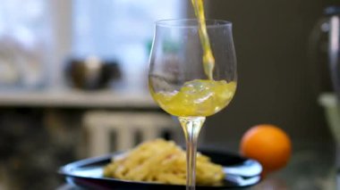 Taze portakalı sıkıyorum. Portakal suyu sıkan birinin resmi. Portakal hamurlu portakal suyu. Elimde taze portakal suyu, Carbonara makarna var.