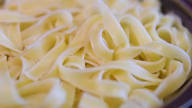 Kuru pappardelle makarna, daire şeklinde dönüş. El yapımı makarna, Turning. Seçici odaklanma. haşlanmış aşçı.