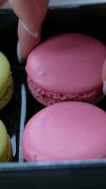 Cam üzerine ışık yansıtan, sarı, yeşil ve beyaz badem kurabiyelerinin sergilendiği bir vitrine yerleştirilmiş çeşitli renkli badem kurabiyelerinin yakın çekimi. Yüksek kalite 4k görüntü