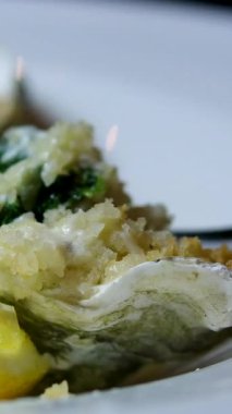 Yakın planda çatalla yemek yiyen bir kadın buzun içinde yeni açılmış istiridyeler. İstiridye ve taze sıvı yarım kabuk konsepti, 4K 'da deniz ürünleri. Yüksek kalite 4k görüntü