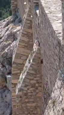 Yunan bayrağı ve insanlarıyla Akropolis duvarlarında çarpıcı bir manzara. Akropolün duvarları