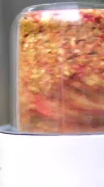 organik kırmızı domatesler ve kırmızı biberli sebzeler 1000 fps hızla karıştırılıyor. Restoranın ahşap masasında. Karıştırıcı Baharat Kavanozu Biberleri