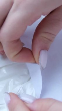 Camembert peynirini açan eller. Camembert beyaz kağıt ambalajla kaplıdır, karakteristik beyaz küf içerir. Camembert peynirinin paketini açıyorum. Yüksek kalite 