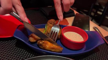 Tavuk kanatları el ve bıçak kızarmış Cordon bleu tabağı, patates kızartması ve mezeler, mozzarella peynirinin eridiğini ve tavuk etinden aktığını gördüm. Yüksek kalite 4k