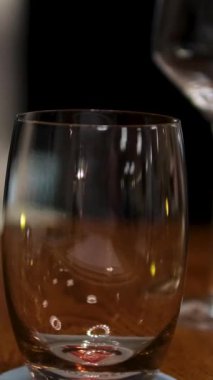 Siyah arka planda izole edilmiş plastik şişeyi tutan ve bardağa su döken yakın plan. Yüksek kalite 4k görüntü