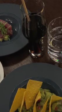 Meksika guacamole ve tortilla cipsi, nachos, yavaş dönen kameranın üst görüntüsü, ulusal tatiller için tipik yemek, cinco de mayonez. Karides ve ton balığı.