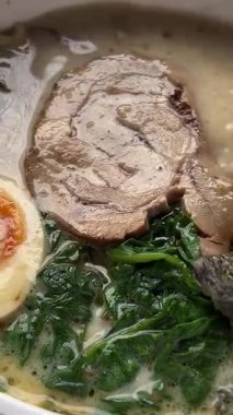 Chopsticks Japon tonkotsu ramen yiyor kalın kremalı domuz kemiği çorbası ve chashu Tokyo sokak eriştesi. Yüksek kalite 4k görüntü