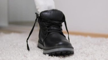 beyaz çoraplarla siyah ayakkabılar giyer, botları bota sokar evde kışlık ayakkabıları dener. Yüksek kalite 4k görüntü