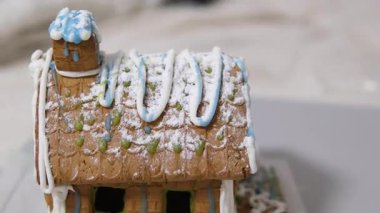 Adım adım ilerliyoruz. Noel 'in önünde zencefilli kurabiye evi dekore eden kız. 