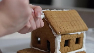 Adım adım ilerliyoruz. Noel 'in önünde zencefilli kurabiye evi dekore eden kız. 