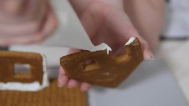 Adım adım ilerliyoruz. Noel 'in önünde zencefilli kurabiye evi dekore eden kız. 