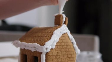 Adım adım ilerliyoruz. Noel 'in önünde zencefilli kurabiye evi dekore eden kız. 