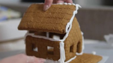 Adım adım ilerliyoruz. Noel 'in önünde zencefilli kurabiye evi dekore eden kız. 