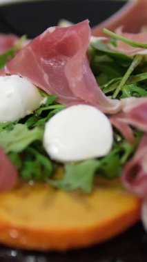 Yerel restoranlarda geleneksel İtalyan yemeği Prosciutto mozzarella roka, Persimmon salatası aperatifleri ve aperatifleri, Akdeniz mutfağı lezzeti. Yüksek kalite 4k görüntü