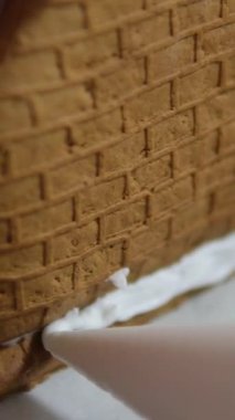 Adım adım ilerliyoruz. Noel 'in önünde zencefilli kurabiye evi dekore eden kız. 