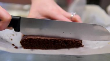 Tahta kesim tahtasında ev yapımı browni kekini ceviz ve kuru üzümle dilimliyorum. Yüksek kalite 4k görüntü