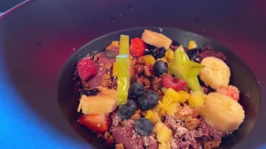 Dondurmalı ve peynirli Lezzetli Meyve Salatası. Meyve salatası ve siyah tabak egzotik meyve taneleri.