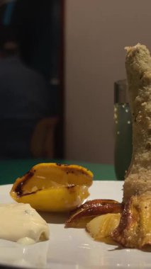 Kadın çatal ve bıçakla doldurulmuş enginardan bir parça alıyor ve yiyor. Sigacik 'teki açık hava restoranı. İzmir, Türkiye. Yüksek kalite 4k görüntü