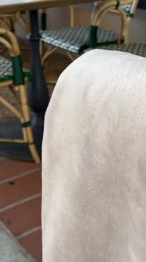 Kafe terasında ahşap bir masa ve teneke kutuda bir çiçek. Soğuğa yakalanan ziyaretçileri örtmek için arkada battaniyeler olmalı. Sonbahar terasında, kasaba meydanında kahve. Kafe sandalyesinde battaniye