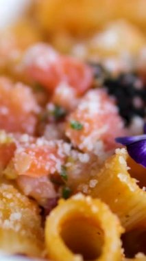 Somon ve karidesli makarnanın üzerine parmesan peyniri dökülüyor. Rigatoni, somon, çiçek.