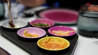 Izgarayı Kore restoranında et pişirmeye hazırlarken garson su ekliyor. Biftek pişirmek. Lokantada barbekü, Kore restoranındaki ızgarada et kızartma..