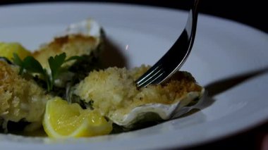 Zarif siyah tabak ve taze limonla lüks restoranlarda deniz taraklarına garnitür koyan kadın, güzel yemek ve yemek sanatının özünü yakalıyor.. 