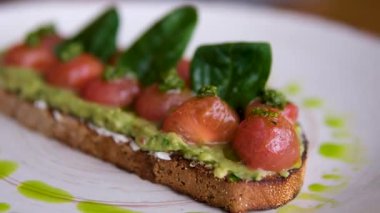 Avokado somonu aperatifleri sağlıklı kahvaltı ya da atıştırmalıklar yumuşak peynir, avokado ve somonlu sandviç yapıyor. Yüksek kalite 4k görüntü