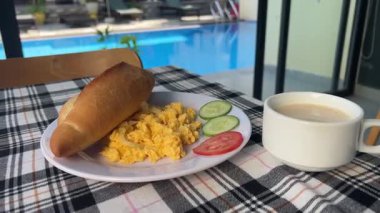 Salatalıklı omlet üzerine kahvaltı ve damalı masa örtüsü bardaklarında beyaz kahve. Yüksek kalite 4k görüntü