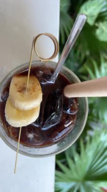 Çikolatalı dondurmalı kahve, çikolatalı dondurma kokteyli. Yoğunlaştırılmış süt ve buzlu Vietnam kahvesi, muz dilimleri bardağı süsler, karıştırır.