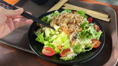 Taze sebzeli salata, canlı bir tat için üzerine sos dökülüyor. Ton balıklı yumurta salatası