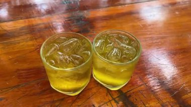 Buzlu buzlu buzlu çay. Islak bardakta taze limonata. Bir dilim limon, nane ve saman. Ağır çekim. Yüksek kalite 4k görüntü