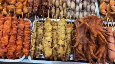 Akşam marketinde kızarmış kurbağa ızgara şiş bir yemek standında hazırlanıyor. Yüksek kalite 4k görüntü