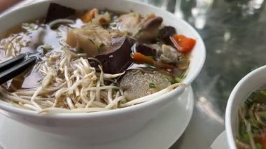 Tayland eriştesi, domuz yahnisi, köfte ve Tayland usulü kanlı erişte çorbası. Kaynamış kan ve haşlanmış domuz bacağı parçaları.