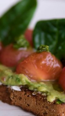 Avokado somonu aperatifleri sağlıklı kahvaltı ya da atıştırmalıklar yumuşak peynir, avokado ve somonlu sandviç yapıyor. Yüksek kalite 4k görüntü