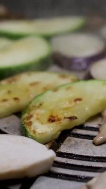 Kabak ya da yeşil sebze ilikleri ateşte kızartılır. Aşçı, her tarafta yemek pişirildiğinden emin olmak için kabak dilimlerini çeviriyor. Yüksek kalite 4k görüntü