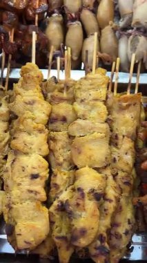 Akşam marketinde kızarmış kurbağa ızgara şiş bir yemek standında hazırlanıyor. Yüksek kalite 4k görüntü