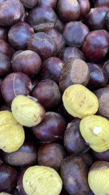 Yenilebilir kestaneler, taze tatlı kestaneler, üst manzara. Şükran Günü. Yenebilir kestaneler Castanea sativa yığını ahşap arka planda, yukarıdan