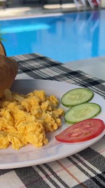 Salatalıklı omlet üzerine kahvaltı ve damalı masa örtüsü bardaklarında beyaz kahve. Yüksek kalite 4k görüntü