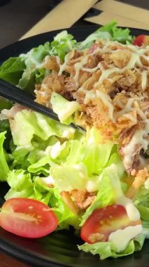 Taze sebzeli salata, canlı bir tat için üzerine sos dökülüyor. Ton balıklı yumurta salatası