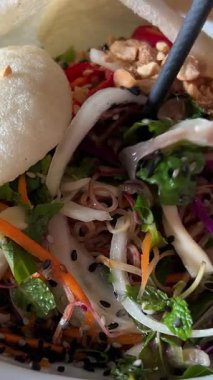 Tabaklar vejetaryen salatası mavi lahana soğanlı çeşitli yeşillikler fındıklar ve pirinç cipsleri çubuklarla yenir. Yüksek kalite 4k görüntü